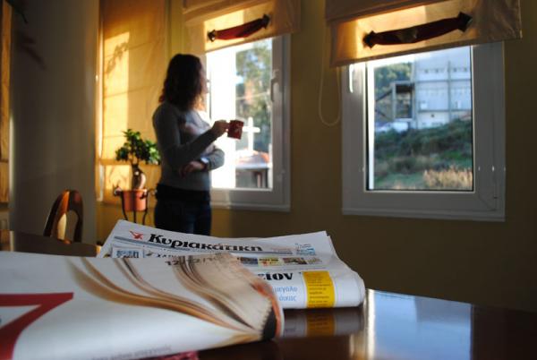 εφημερίδα, γυναίκα πίνει καφέ και κοιτάει από παράθυρο