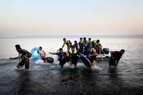 άνδρες με σωσίβια γιλάκα βγαίνουν απο μία βάρκα