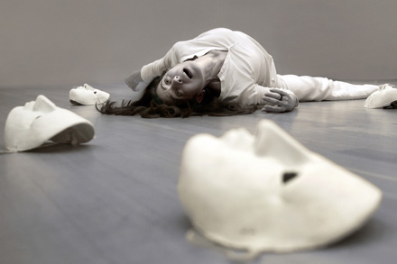 ηθοποιίος πεσμένη στο πάτωμα και δίπλα της 3 άσπρες γύψινες μάσκες