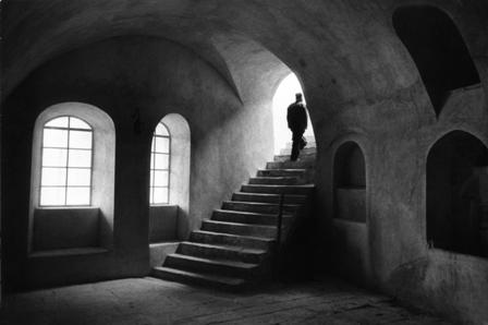 μοναχός ανεβαίνει τα σκαλιά στο εσωτερικό κάποιου μοναστηριού