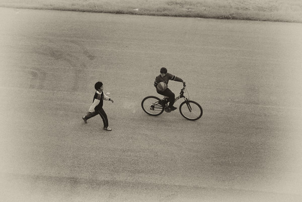 παιδί κάνει ποδήλατο και ένα άλλο τρέχει απο πίσω