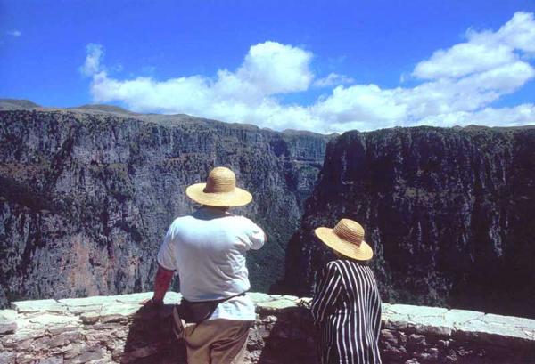 δύο τουρίστες με ψάθινα καπέλα θαυμάζουν τη θέα