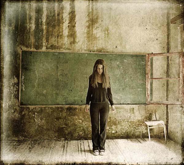 γυναίκα στέκεται μπροστά από πράσινο πίνακα σχολικής αίθουσας