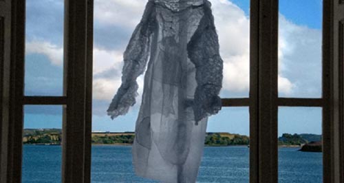 φόρεμα κρεμασμένο σε παράθυρο με θέα τη θάλασσα
