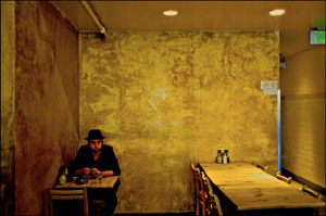 άντρας κάθεται σε τραπέζι άδειου μπαρ