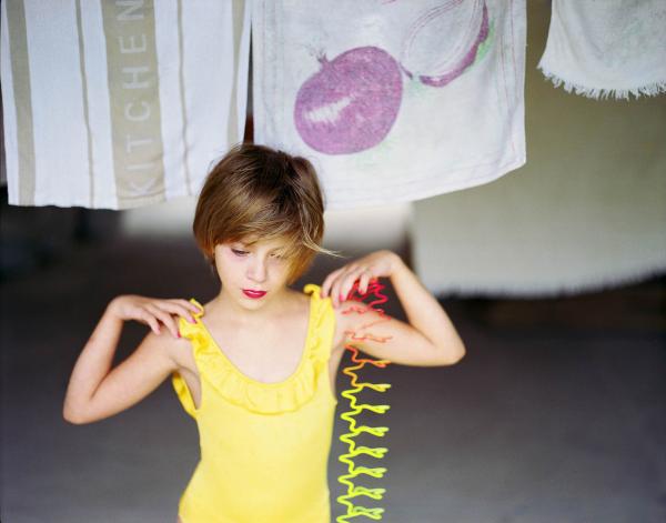 κοριτσι με κίτρινο μαγιώ κάνει μία χορευτική φιγούρα, πετσέτες