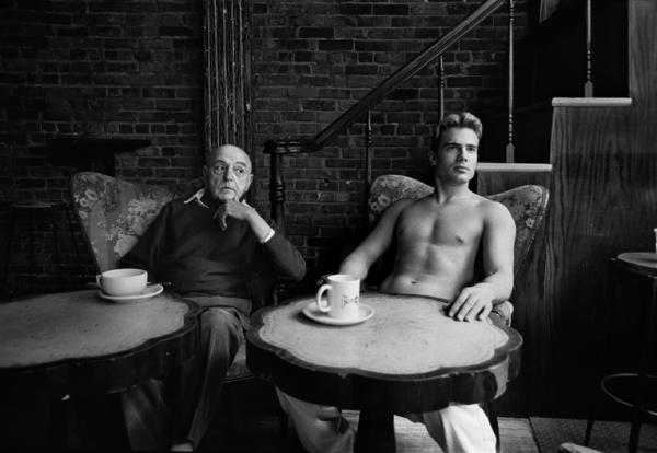 δύο άντρες καθισμένοι σε πολυθρόνες, ο ηλικιωμένος ντυμένος, ο νεος γυμνός