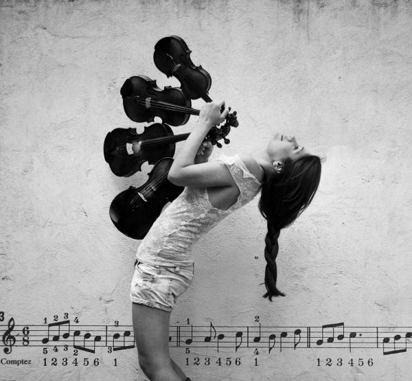 ασπρόμαυρη φωτογραφία, κορίτσι κρατάει 4 βιολιά και χορεύει