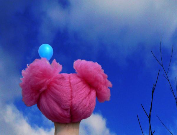 πάνινη κούκλα με ροζ μαλλί κοιτάει ένα γαλάζιο μπαλόνι στον ουρανό
