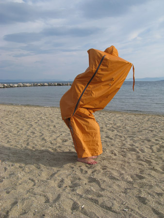άνθρωπος όρθιος μέσα σε πορτοκαλί sleeping bag