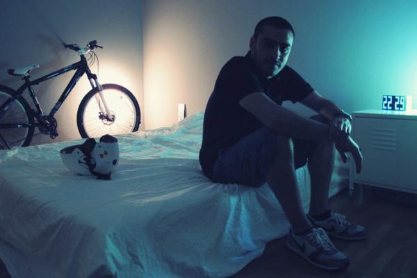άντρας καθισμένος στο κρεβάτι του, κράνος ποδηλάτου, ποδήλατο