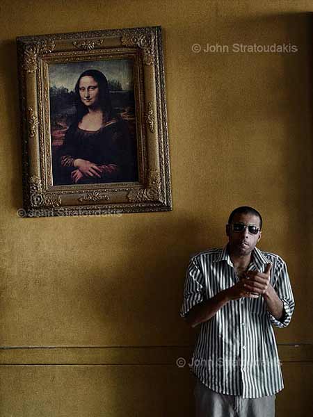 άντρας με γυαλιά και τσιγάρο ποζάρει μπροστά από το πίνακα της Μόνα Λίζα