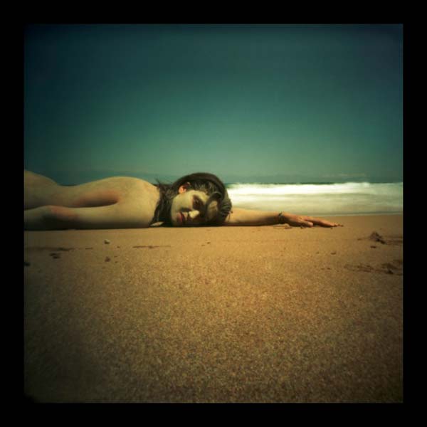 γυμνή κοπέλα ξαπλωμένη σε παραλία