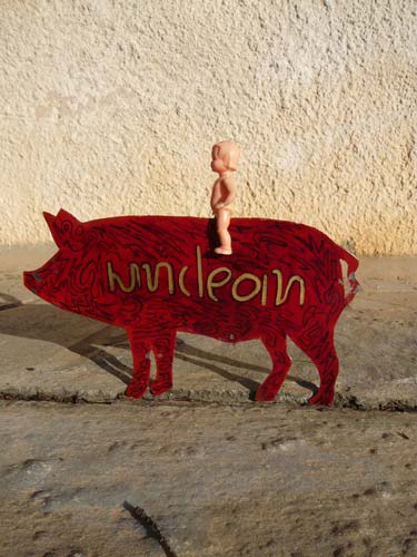 κόκκινο γουρούνι με επιγραφή unclean και πάνω του μικρό κουκλάκι