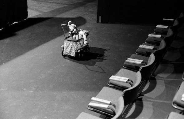 παιδικό καρότσι παιχνίδι μπροστά από μια σειρά θέσεων σε θέατρο