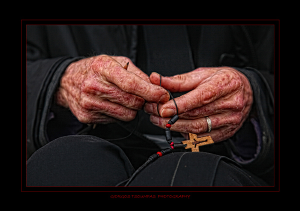 γερασμένα χέρια μοναχού απο το Άγιο Όρος φτιάχνουν ένα σταυρό για το λαιμό