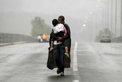ένας πατέρας κρατά αγκαλιά και φιλά την κόρη του καθώς περνάνε τα σύνορα του ΠΓΔΜ