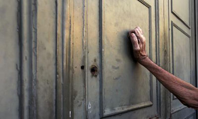 το χέρι ενός συνταξιούχο ακουμπά στην πόρτα της εθνικής τράπεζας στην Αθήνα