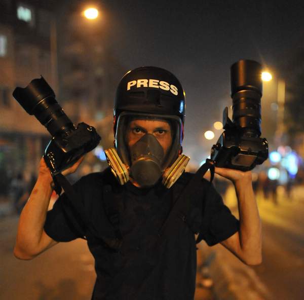 Φωτορεπόρτερ με μάσκα οξυγόνου και δύο φωτογραφικές μηχανές στα χέρια