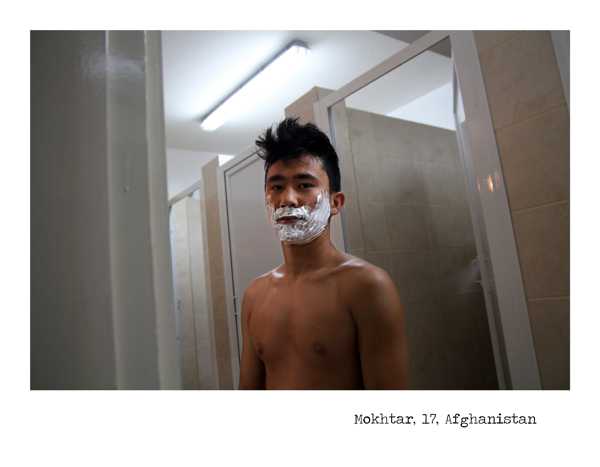 έφηβος από το Αφγανιστάν με αφρό ξυρίσματος στο πρόσωπο στέκεται έξω από τουαλέτα