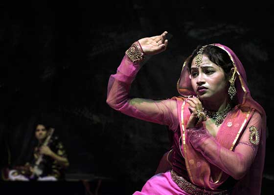 Ινδή κοπέλα με παραδοσιακή ινδική ένδυση χορεύει καθιστή