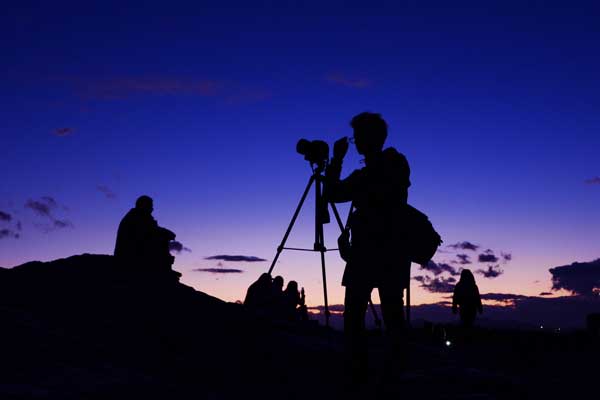 ένας φωτογράφος φωτογραφίζει με μοβ ουρανό