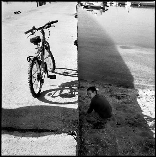 ασπρόμαυρη φωτογραφία ενός παιδιού κι ενός ποδηλάτου