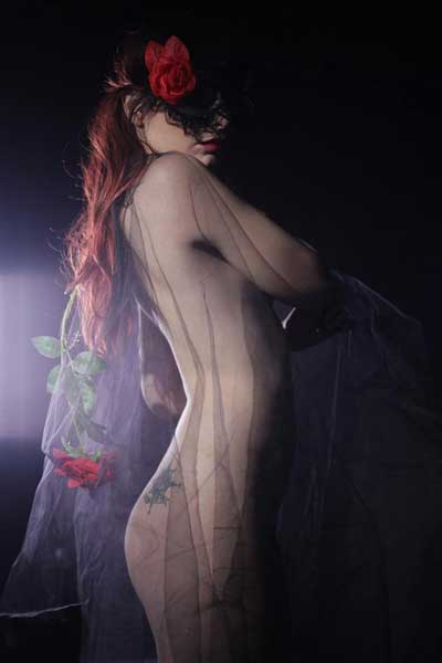γυμνή κοπέλα με κόκκινα μαλλιά καλυμμένη με μαύρο τούλι
