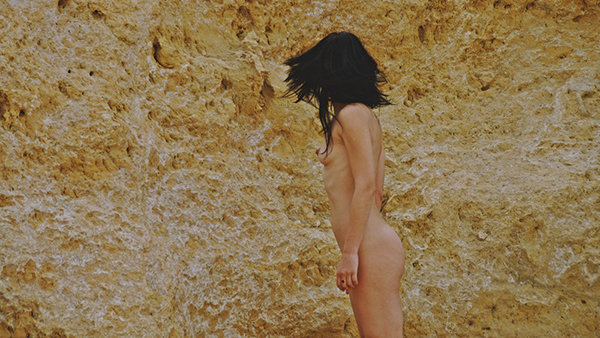 φωτογραφία μίας γυμνής γυναίκας με γυρισμένο το κεφάλι