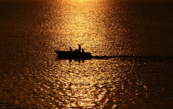 βάρκα σε θάλασσα στη δυση του ηλίου