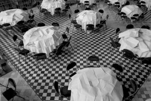 ασπρόμαυρη φωτογραφία, τραπέζια σε σχήμα ροτόντα σκεπασμένα με λευκά τραπεζομάντηλα, μάυρες καρέκλες