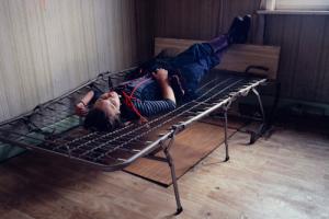 παιδί ξαπλωμένο σε κρεβάτι χωρίς στρώμα