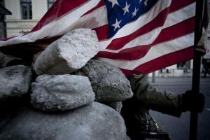 στρατιώτης κρατάει την αμερικανική σημαία, πέτρες
