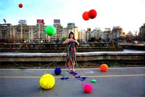 γυναίκα φοράει ένα περίεργο ρούχο από το οποίο κρέμονται μπαλόνια
