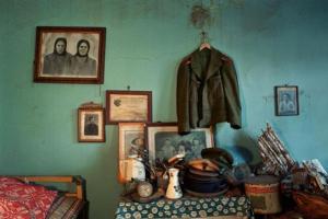 εσωτερικό παλιού σπιτιού, παλιές φωτογραφίες σε κάδρα, ένα σακάκι κρεμασμένο στο τοίχο