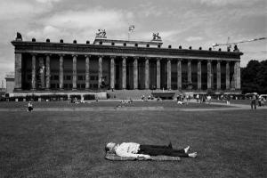 άντρας ξαπλωμένος μπροστά στο γρασίδι κτηρίου του Βερολίνου
