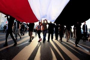 διαδηλωτές σε πορεία κρατάνε σημαία