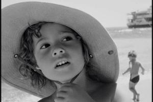 ασπρόμαυρη φωτογραφία, παιδί με ψάθινο καπέλο σε παραλία, πορτραίτο