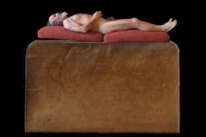 αυτοπορταίτο, γυμνός άντρας πάνω σε τεράστιο ξύλινο κρεβάτι