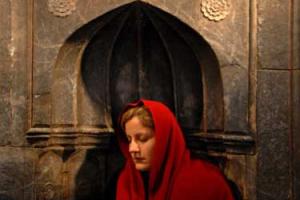 μωαμεθανή γυναίκα με κόκκινη μαντήλα προσεύχεται