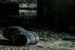 φωτογραφία: Βασίλης Τσιώλης / ασπρόμαυρη φωτογραφία, ένα παπούτσι πεταμένο σε χώματα