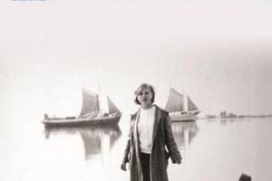 ένα κορίτσι στέκεται στη λιμνοθάλασσα του Μεσολλογίου και στο βάθος δύο ιστιοφόρα