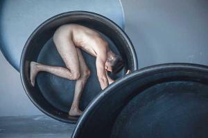 άνδρας γυμνός μέσα σε ένα μεγάλο κυκλικό δοχείο