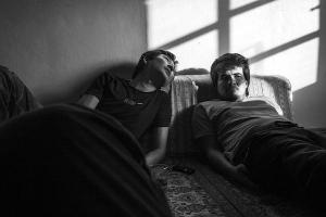Ασπρομαυρή φωτογραφία με δύο άνδρες που κάθονται σε ένα καναπέ