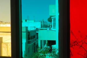 φωτογραφία κτηρίων μέσα απο πολύχρωμο παράθυρο