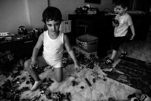 ασπρόμαυρη φωτογραφία δύο μικρών αγοριών που παίζουν με τα παιχνίδια τους στο σαλόνι του σπιτιού