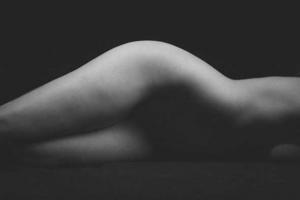 ασπρόμαυρη φωτογραφία μίας ξαπλωμένης γυμνής απο τη μέση και κάτω γυναίκας