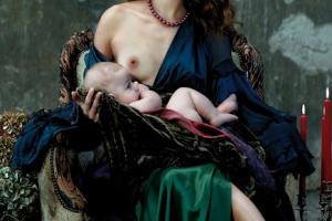 γυναικα παριστάνει τη Μαντόνα, καθισμένη με ενα βρέφος αγκαλιά και με το στήθος γυμνό